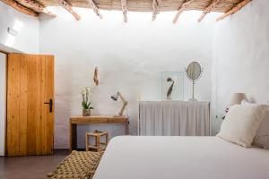 um quarto com uma cama e uma mesa com um espelho em Can Quince de Balafia - Turismo de Interior em Sant Llorenç de Balafia