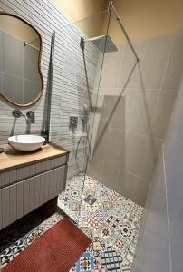 une salle de bain avec une douche avec un lavabo et un miroir dans l'établissement Appart familial hyper centre Troyes, à Troyes