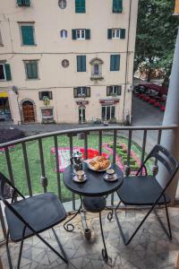 a table with a plate of food on a balcony at Casa Paolina in Lucca