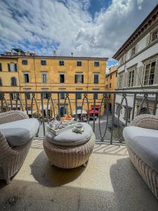 uma varanda com duas cadeiras e uma mesa em frente a um edifício em Casa Paolina em Lucca