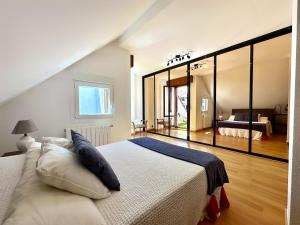 1 dormitorio con 1 cama blanca grande y espejo grande en El Camarote - 6019 en Noja