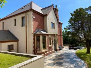a large brick building with a pathway in front of it at Coastal Escape: 4 bed mansion in Port Talbot
