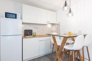 a kitchen with white cabinets and a table and chairs at Studio apartment Ičići by the sea in Ičići +29 photos