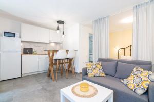 a living room with a blue couch and a kitchen at Studio apartment Ičići by the sea in Ičići