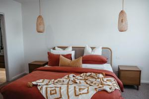 a bedroom with a large bed with red sheets and pillows at Southern Pause Port Campbell in Port Campbell