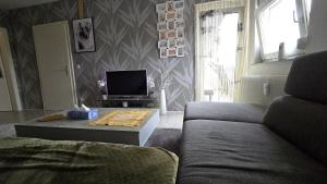 a living room with a couch and a tv at sunny City Apartment in Villingen-Schwenningen