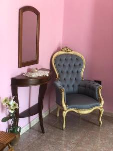 a blue chair next to a table and a mirror at B&B La Tana dell'Orso in Guardia Sanframondi