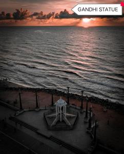 a view of the ocean with the sun setting on the beach at The Elite Beachview in Pondicherry