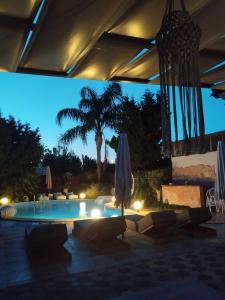 uma piscina com um guarda-sol e uma palmeira à noite em Luxury Villas Chrysa Private Pool & Spa em Nafplio