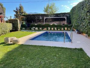 una piscina en un patio con arbustos en Hotel Betriu, en Coll de Nargó