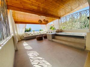 a large room with a bath tub and a window at Alexandrina in Mola Kalyva