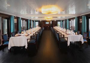 a row of tables in a banquet hall with white table cloth at Bhaya Halong Cruises in Ha Long