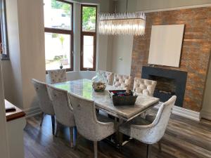 a dining room with a table and chairs and a fireplace at Coastal Escape: 4 bed mansion in Port Talbot