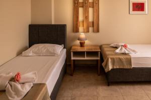 a bedroom with two beds and a table with a lamp at Rodos House in Pomorie