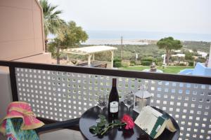 a table with a bottle of wine and glasses on a balcony at Asteras Apartments in Xerokampos