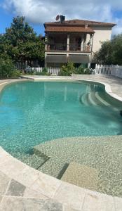 una piscina con una casa sullo sfondo di Agriturismo Montefabbrello a Magazzini