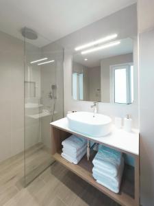 La salle de bains est pourvue d'un lavabo et d'un miroir. dans l'établissement ASTIKON Xenofontos Suites, à Athènes