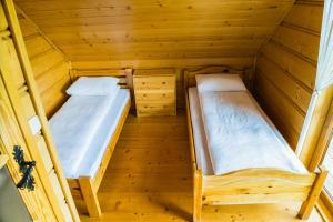 2 łóżka piętrowe w drewnianym domku w obiekcie Domek pod lasem w mieście Mizerna
