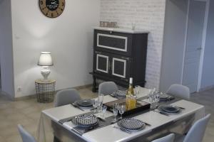 a dining room with a table with chairs and a microwave at Gite de Bel-Air in Pontlevoy