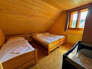 1 Schlafzimmer mit 2 Betten in einer Holzhütte in der Unterkunft Apartmány Podťaté in Velké Karlovice