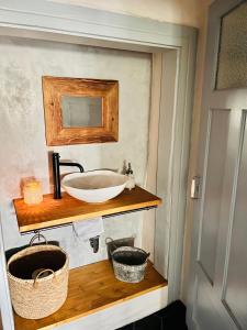 uma casa de banho com um lavatório numa prateleira de madeira em Na Nebi 187 em Becov nad Teplou
