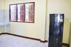 a black refrigerator in a room with a window at Baanrimklong bungalow in Ko Chang