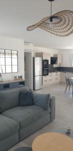 a living room with a couch and a kitchen at La Perséide - Maison neuve 900 m plage in Notre-Dame-de-Monts