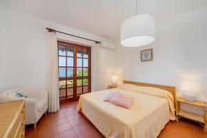 Schlafzimmer mit einem Bett und einem Fenster in der Unterkunft Sea View Mucchi Bianchi in Baja Sardinia