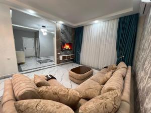 a living room with a large couch and a fireplace at Qafqaz Modern Luxryland in Gabala