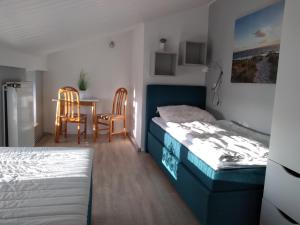 a bedroom with two beds and a table and chairs at FeWo 8 im 1Stock, Terrasse mit Strandkorb in Dahme