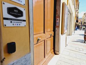 une porte sur un bâtiment avec un panneau sur celui-ci dans l'établissement HomeHoliday 2,0 - MY PLACE SANREMO, à Sanremo