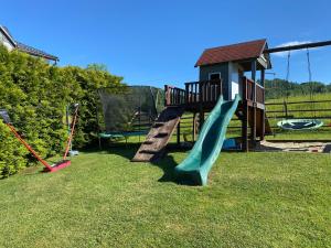 a playground with a slide in the grass at Domki Mizerna - Czorsztyn - Pieniny in Mizerna