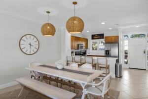 a dining room with a table and a clock on the wall at NEW LISTING! Waterfront Villa 35 with boat slip townhouse in Marathon