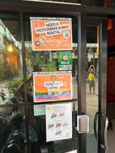 uma janela de uma loja com cartazes em Rainbow hostel em Chiang Mai