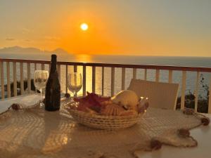 einen Tisch mit einem Korb mit Essen, einer Flasche und Gläsern in der Unterkunft Ponza Vista Mare in Ponza