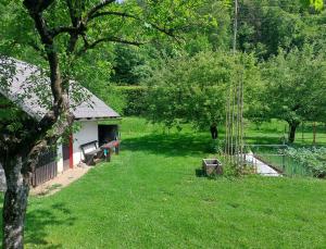 a yard with a bench and a building and trees at Apartma Fekonja in Bled