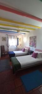 a room with four beds with colorful pillows on them at Casa De Terena in Terena