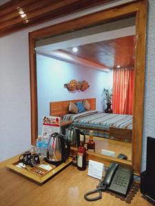 CITI HOTEL في Hilongos: مرآة تعكس غرفة نوم مع سرير وهاتف