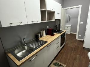 a kitchen with a stainless steel sink and white cabinets at DaMaky in Reggio di Calabria