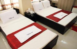 two beds in a hotel room with towels on them at White Inn luxury Residential Hotel in Chittagong +10 photos