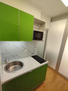 eine Küche mit grünen Schränken und einem Waschbecken in der Unterkunft Bella vista - cozy apartment with a great view in Split