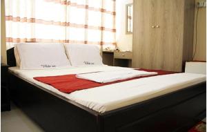 a bed with white sheets and a red blanket on it at White Inn luxury Residential Hotel in Chittagong