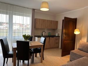 una cucina e una sala da pranzo con tavolo e sedie di Twardowski Łeba a Łeba