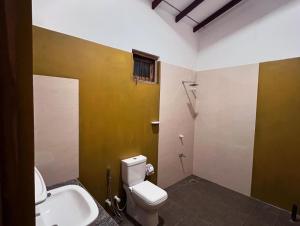 a bathroom with a toilet and a sink at Sunrise oasis retreat in Habarana