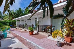 eine Terrasse mit Topfpflanzen vor einem Haus in der Unterkunft Chez Marston in La Digue