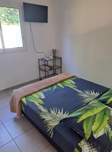 a bedroom with a bed with a colorful blanket at Résidence Corail in Sainte-Rose