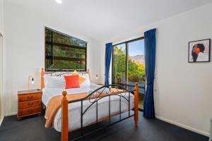 a bedroom with a bed and a window at Goldfield Holiday Home in Queenstown