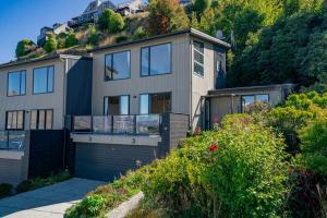 a house on a hill with a garage at Goldfield Holiday Home in Queenstown