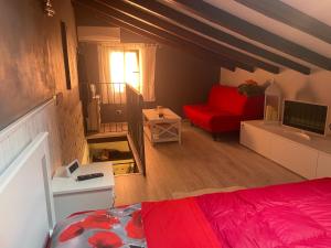 a bedroom with a red bed and a red couch at La dolce dimora in Chioggia
