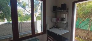 een keuken met twee ramen en een koffiezetapparaat op een aanrecht bij VILLA Le MARVIVO in La Seyne-sur-Mer